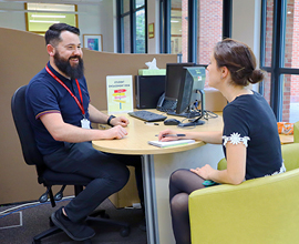 Image of student seeking advice from support staff