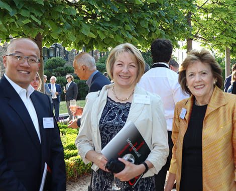 Delegates smile for the camera at a garden drinks party
