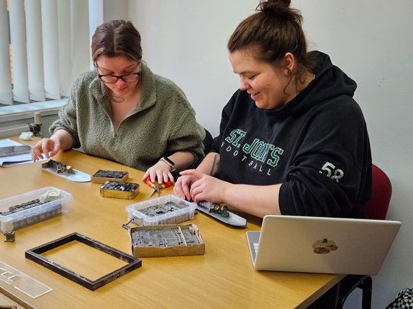 Students at desk using printing press
