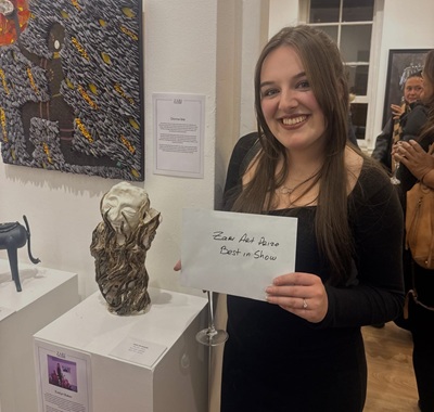 Art student stood next to award winning sculpture