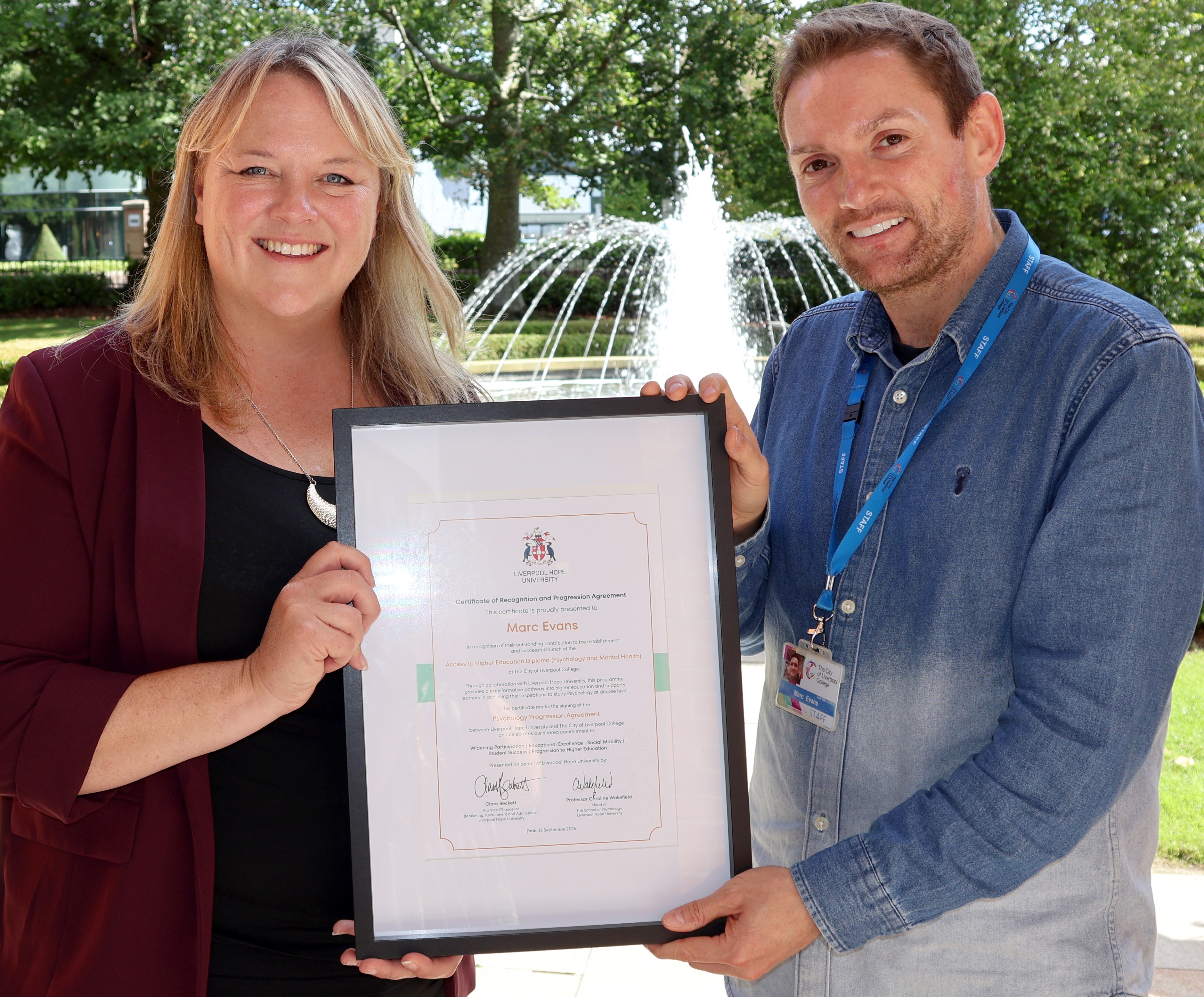 Professor and subject lead with a framed signed agreement