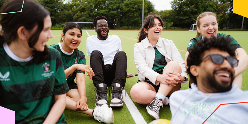 Undergraduate students socialising together on a sports pitch, representing campus life, community and the undergraduate student experience.