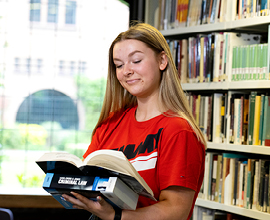 Image of a student reading in the library