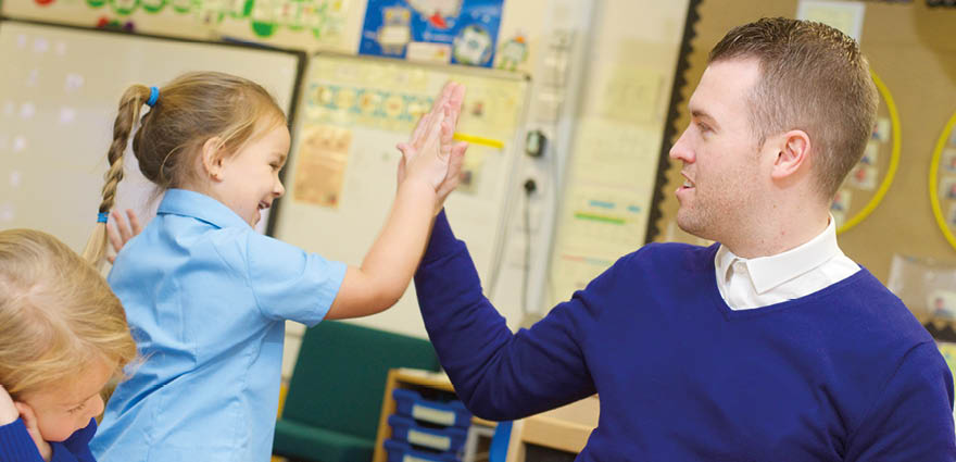 Image of male teaching 'high-fiving' a young girl.