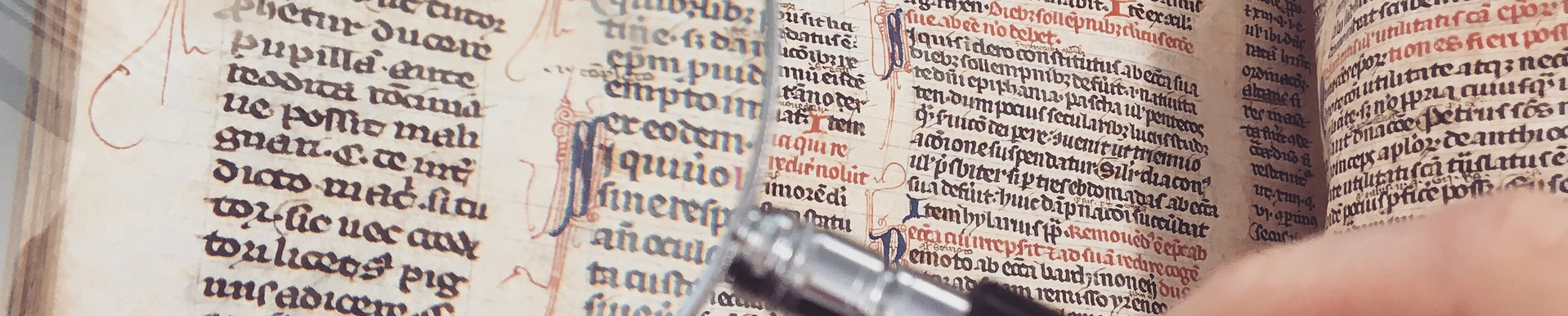 Detail of using a magnifying glass to read a manuscript