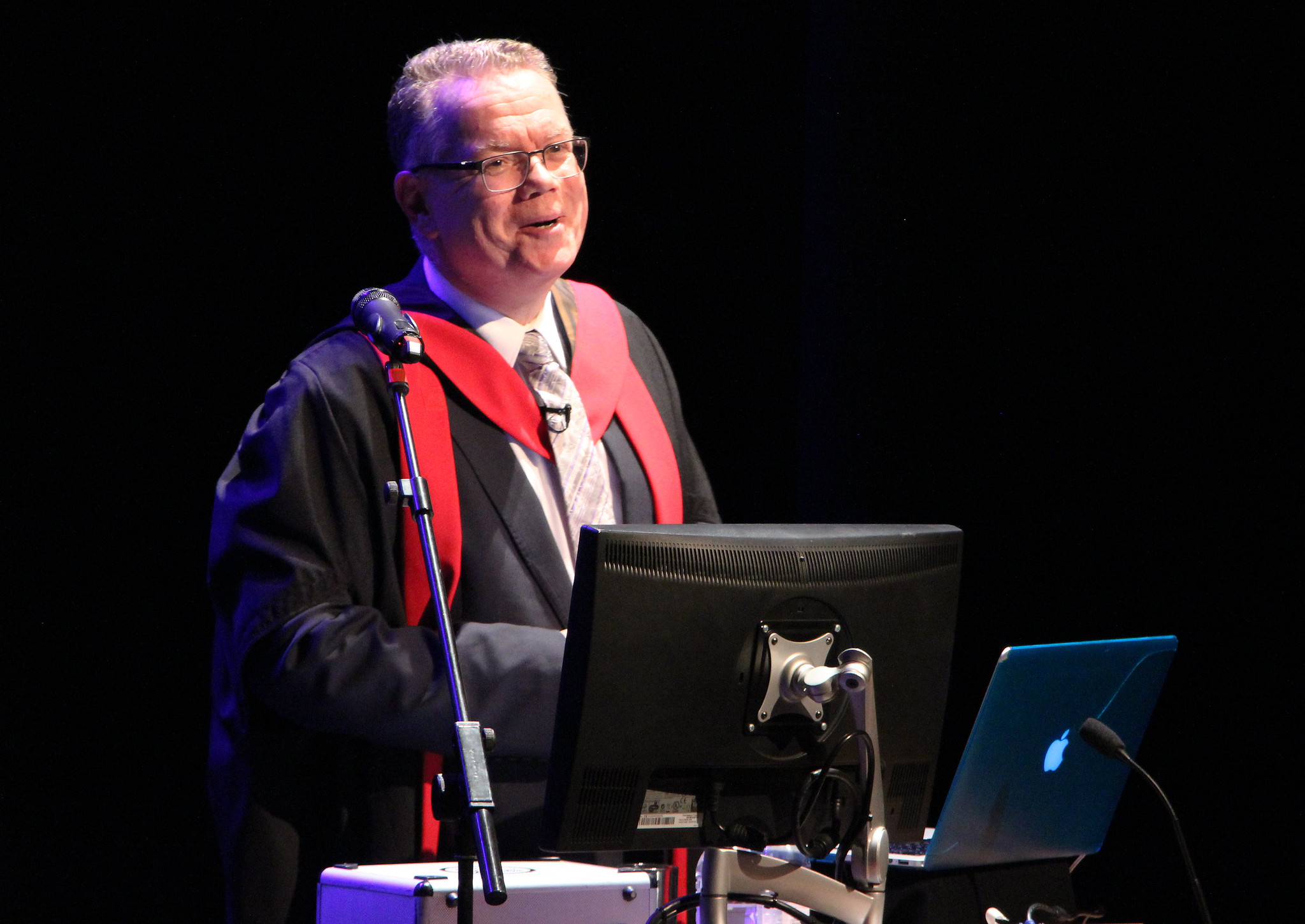 Professor stands in front of screen to deliver lecture