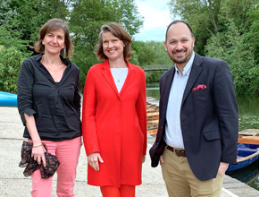 Two ladies and man smile at camera