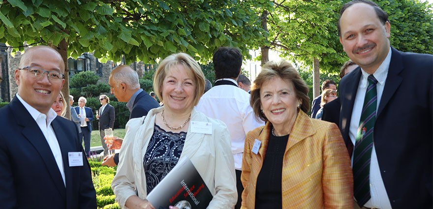 Delegates smile for the camera at a garden drinks party