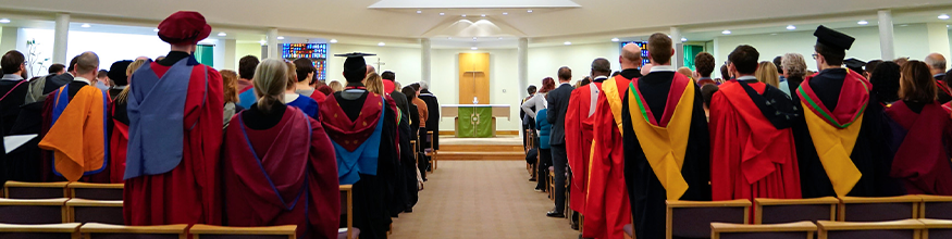 The back of academics wearing cap and gowns in the Hope Chapel