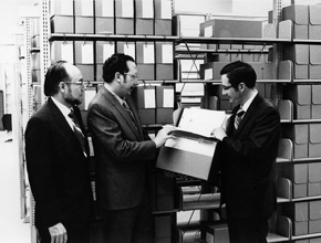 Three gentlemen looking through files