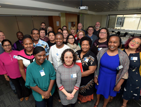 conference members stand for photo together all smiling