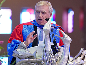 Person in gown address the audience at the graduation ceremony