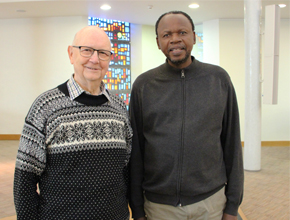 Two men stand side by side for a photo together