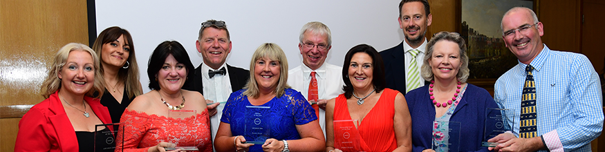 Award winners hold their trophies and smile at camera