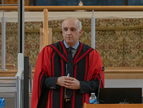 Professor wearing gown and delivering speech