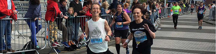Two runners smiling as they cross the finish line