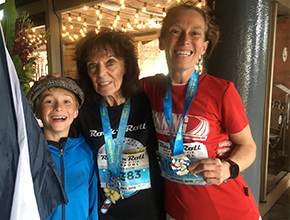 Runners pose for photo holding their medals all smiling