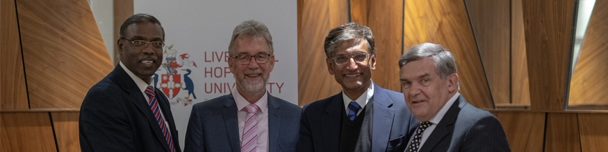 Professor Gerald Pillay smiling with three other people