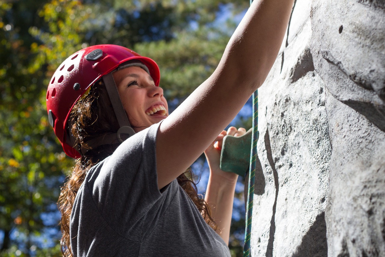 woman scaling artificial climbing wall