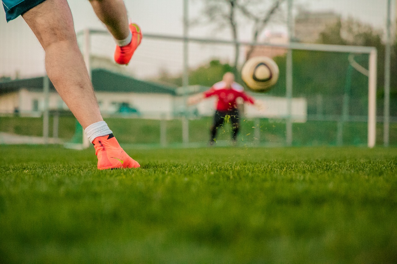 two men playing football in a park