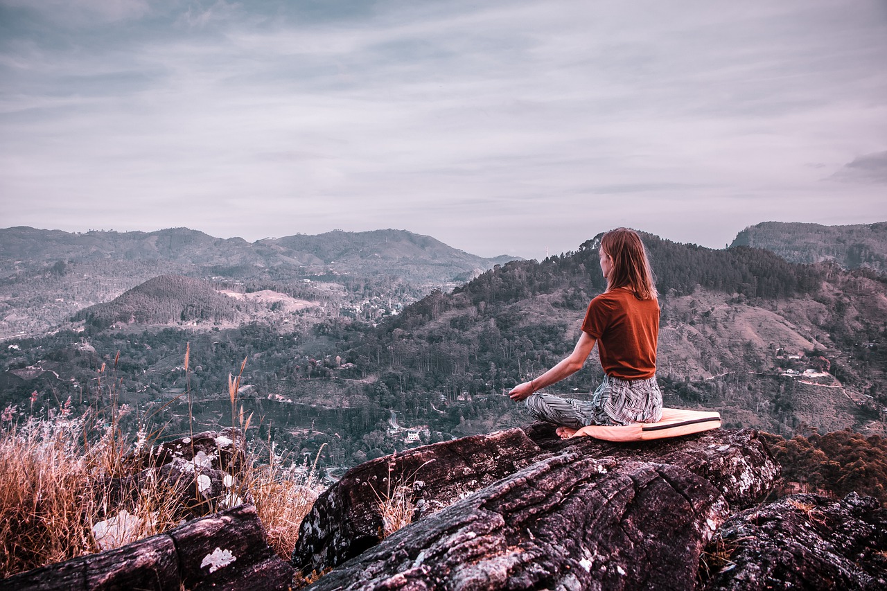 a woman practicing mindfulness on a hilltop