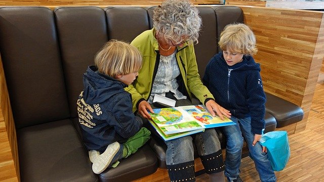 woman reading to two children