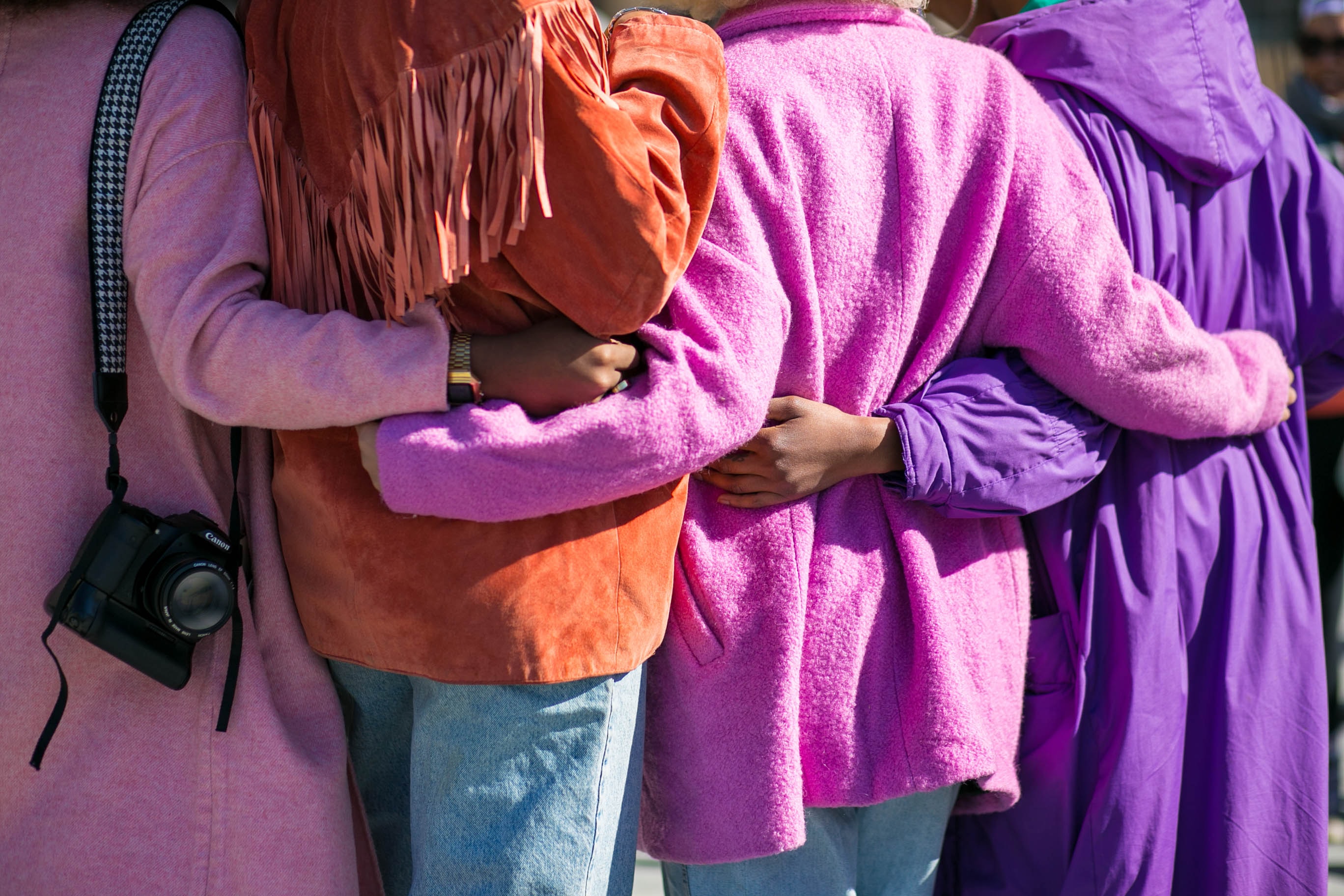 People standing with arms around each other