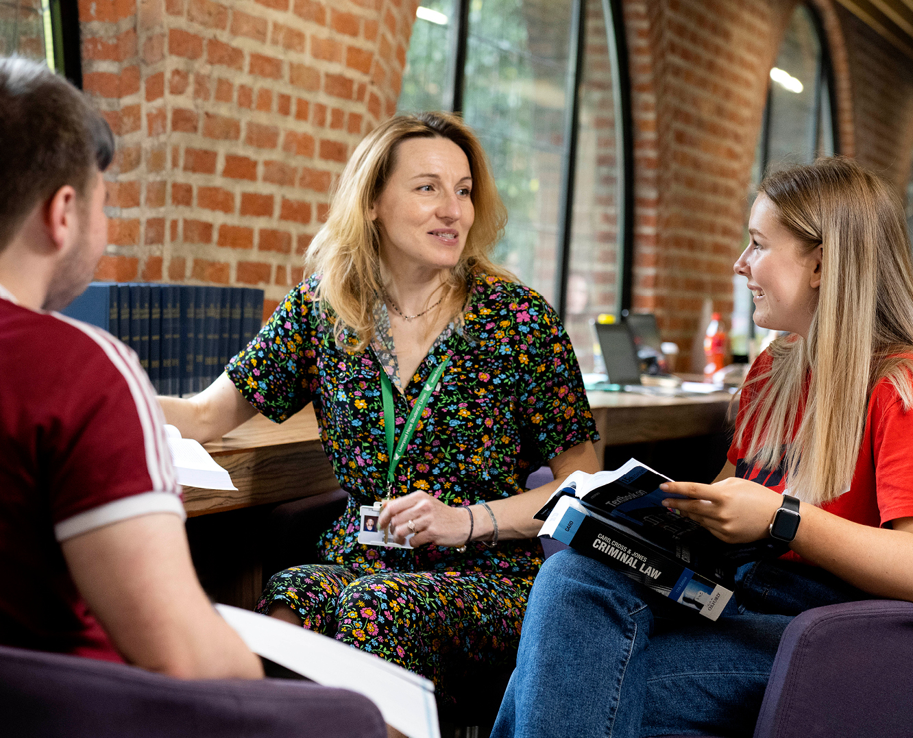 Three students having a discussion in the library